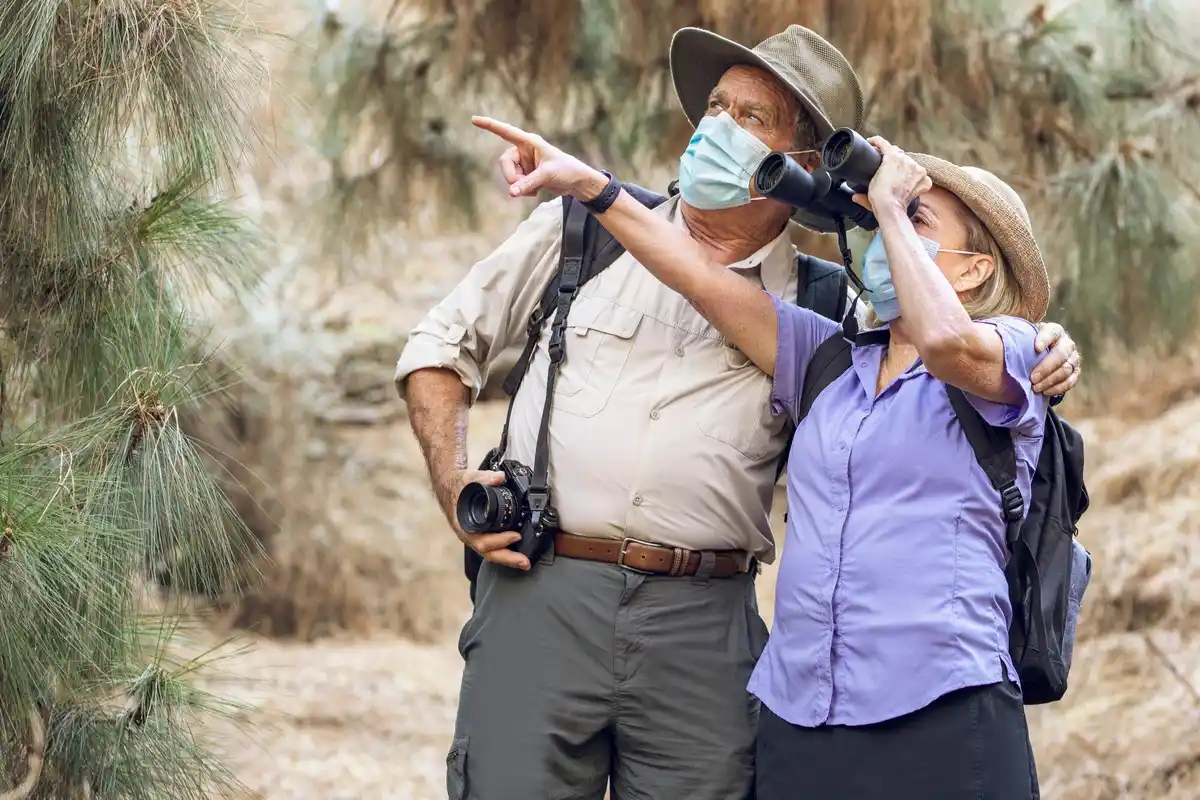 group of tourists with gas masks climbing volcano