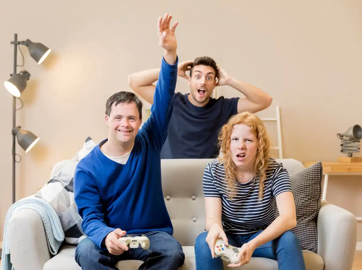 elderly man winning video game with smiling teenagers couch
