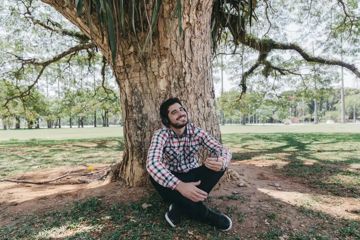 man relaxing under old tree dutch park