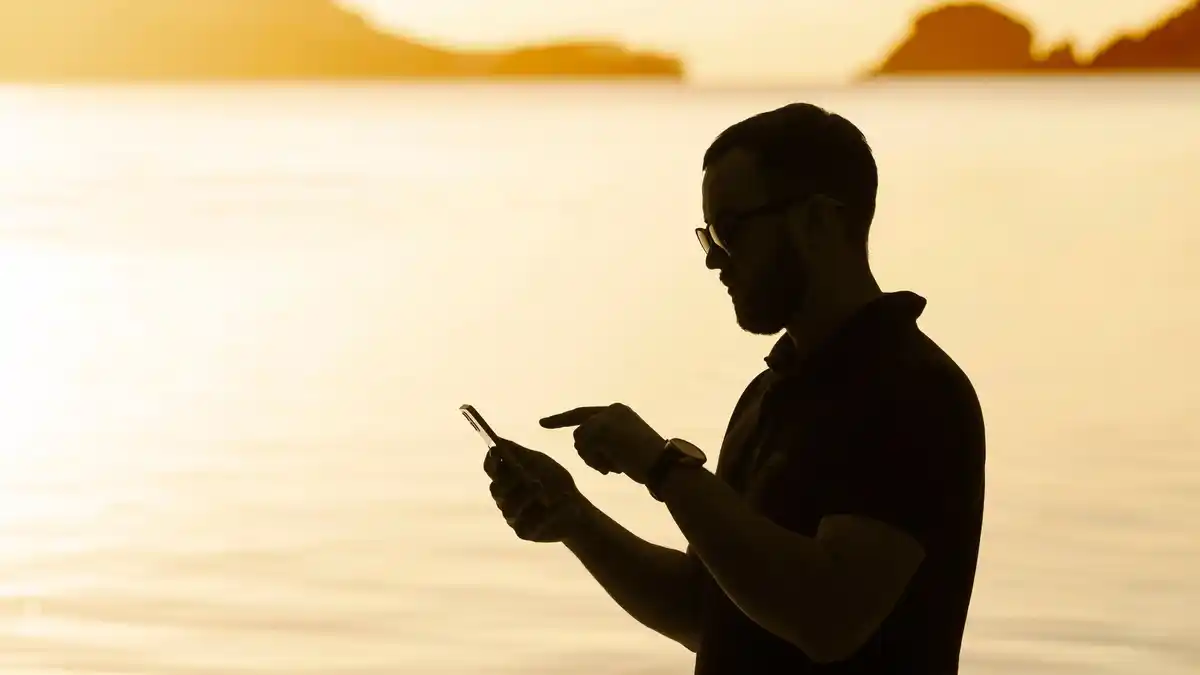 person holding smartphone to sky with planet visible