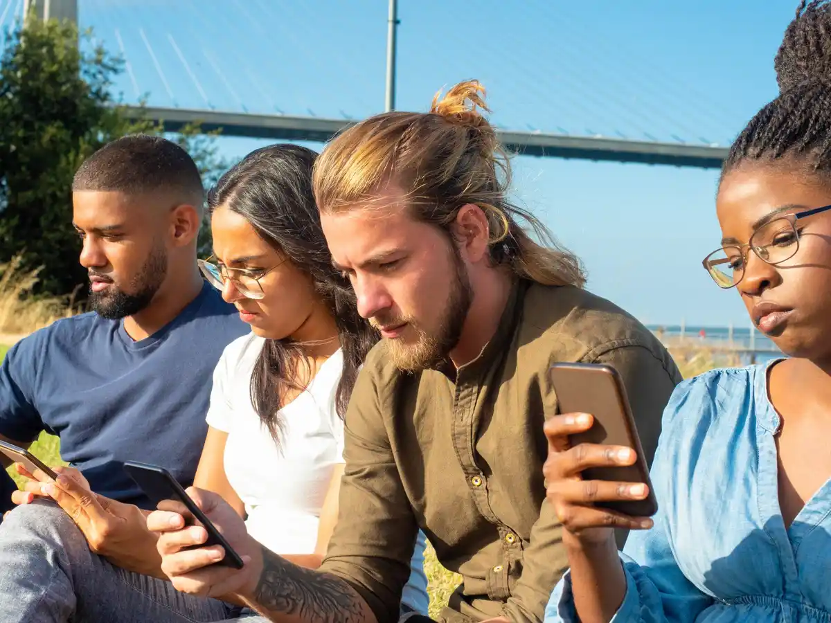 Dutch teenagers group laughing with old mobile phones