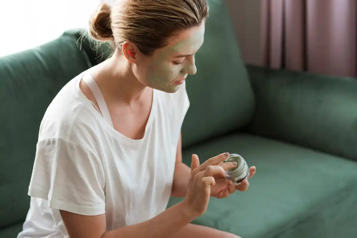 Dutch woman holding glass of water during headache at home