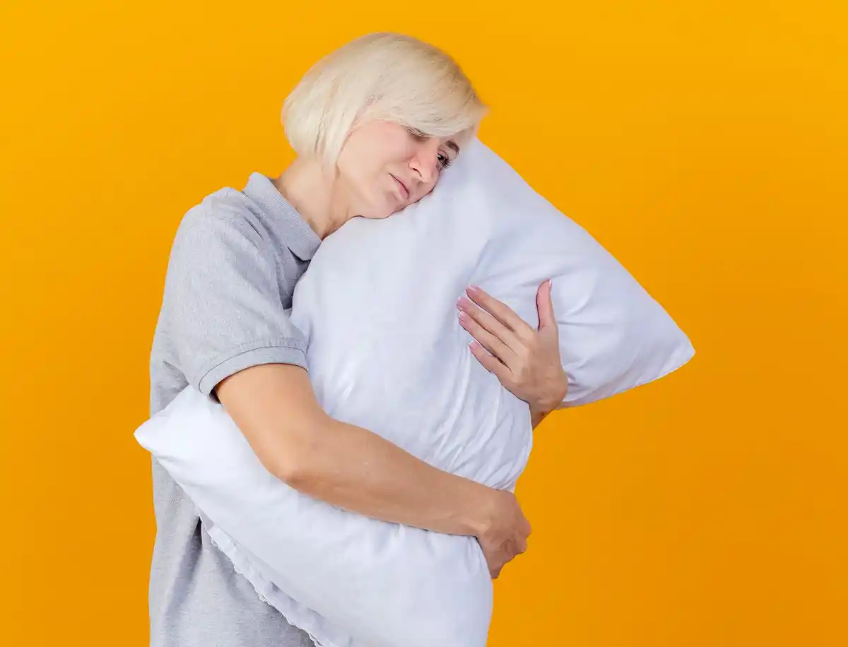 pillow between knees side sleeping mature woman