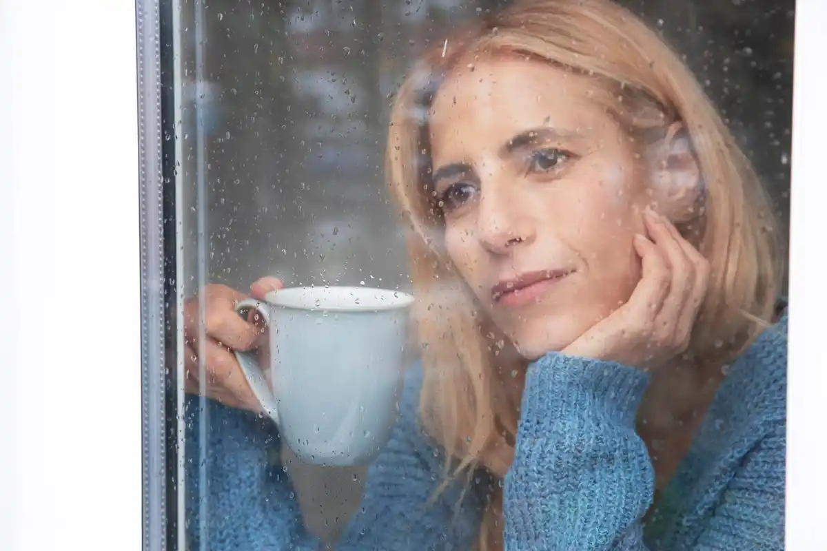 woman crying window rain emotional portrait