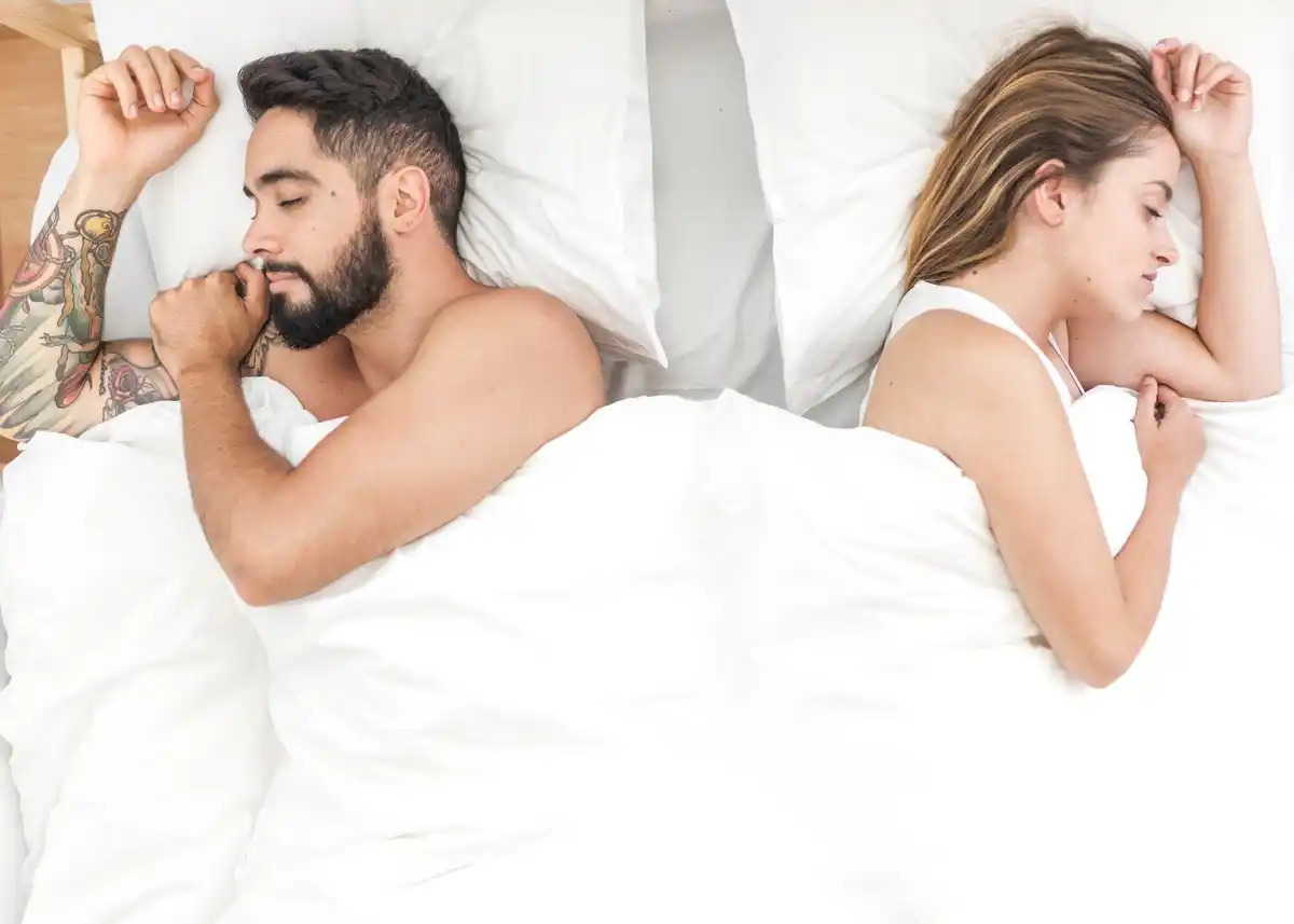 dutch couple sleeping opposite sides bed