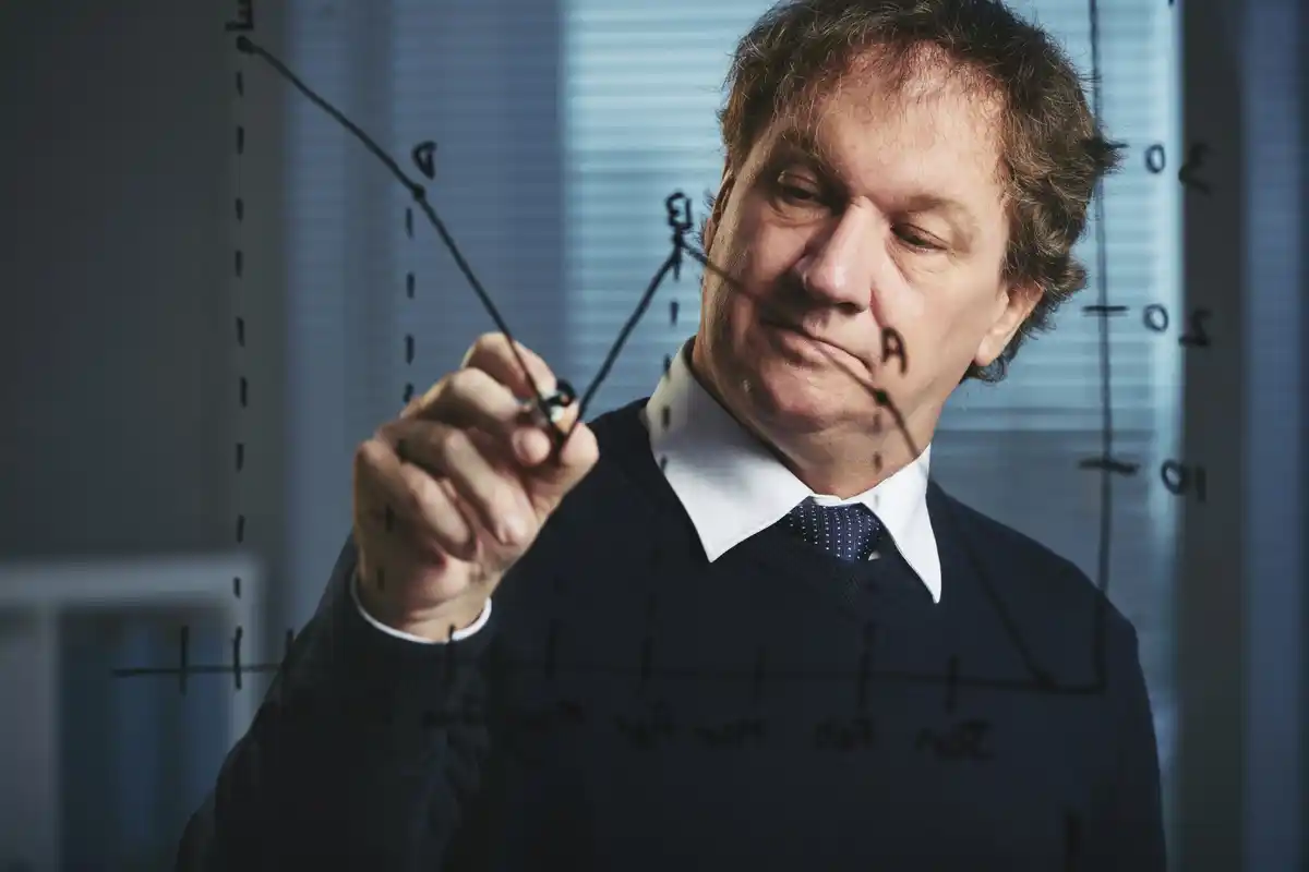 Dutch scientist discussing spacetime with blackboard equations