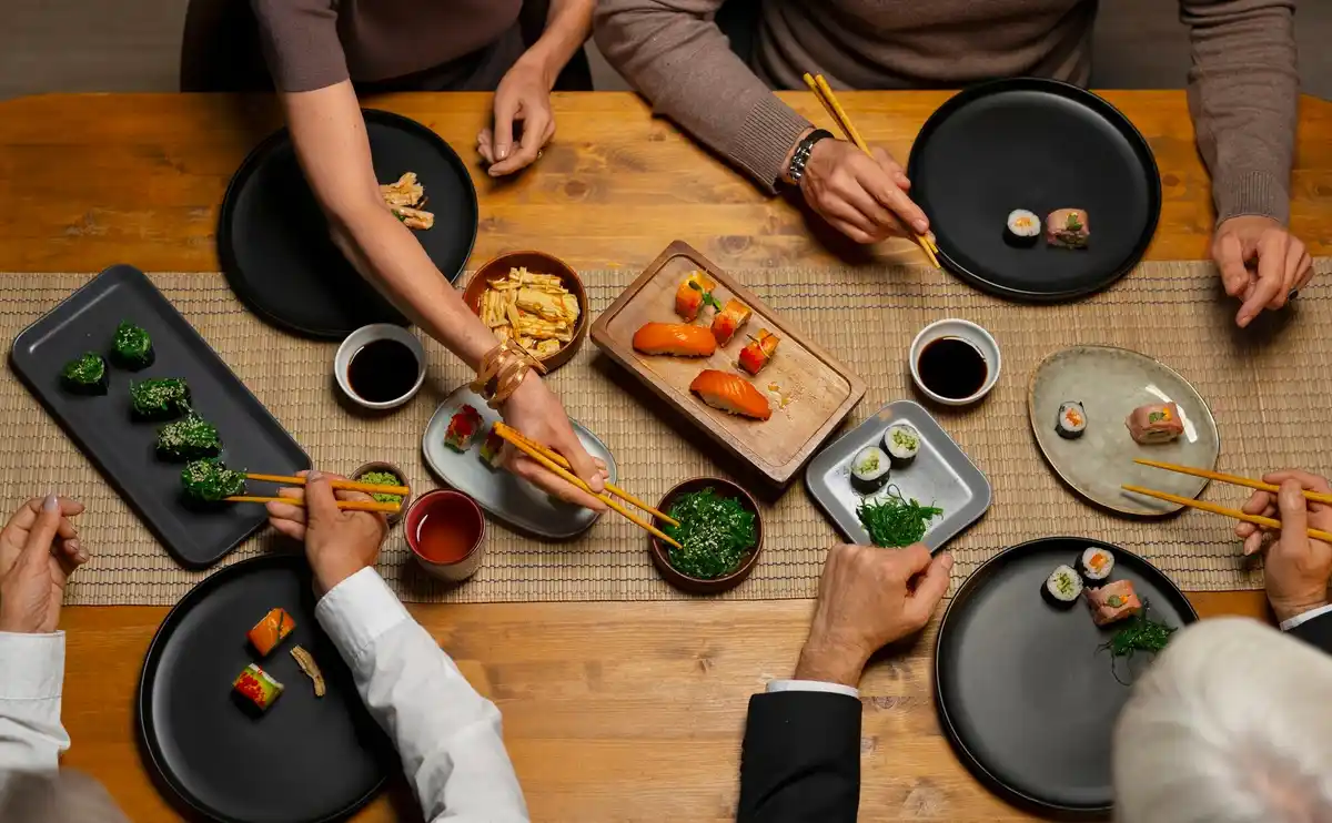 korean communal dining table with banchan and people sharing food
