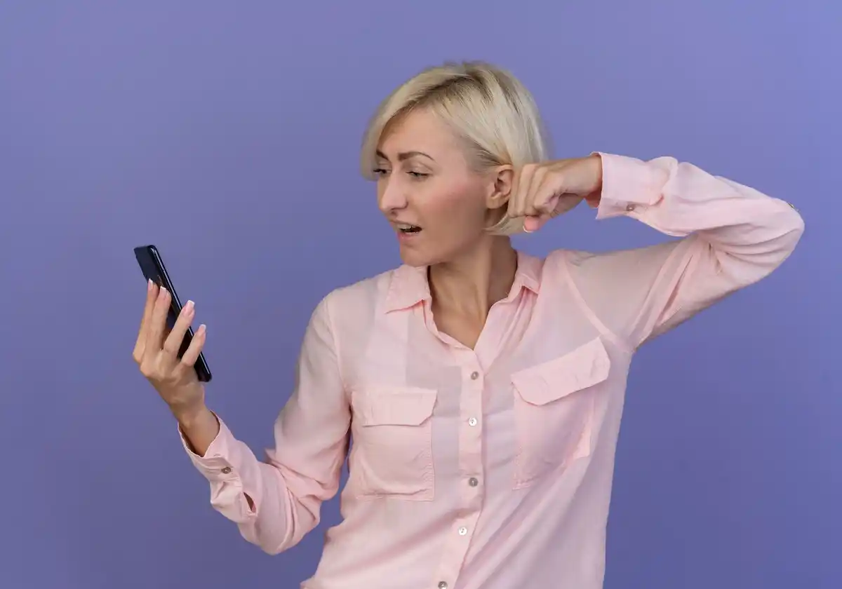 middle aged person holding smartphone looking confused technology