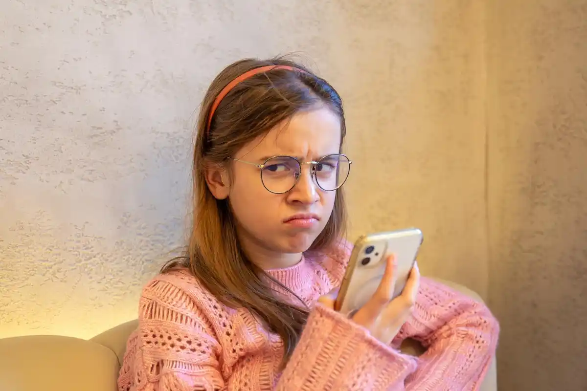 Dutch teenager looking at phone with forgetful expression
