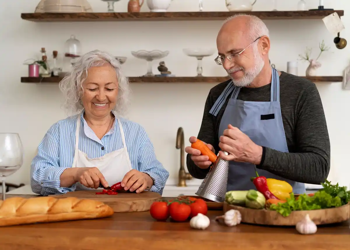 happy Dutch senior couple cooking traditional meal in home kitchen