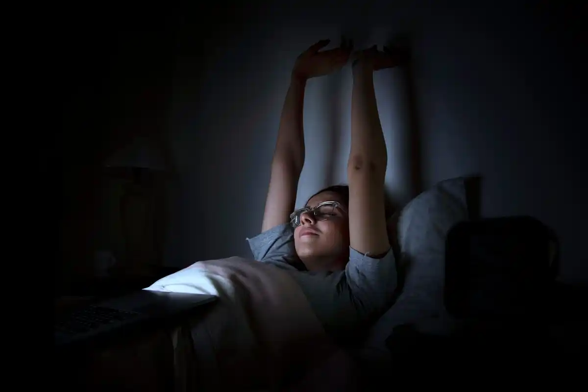 person awake in bed moonlight window insomnia