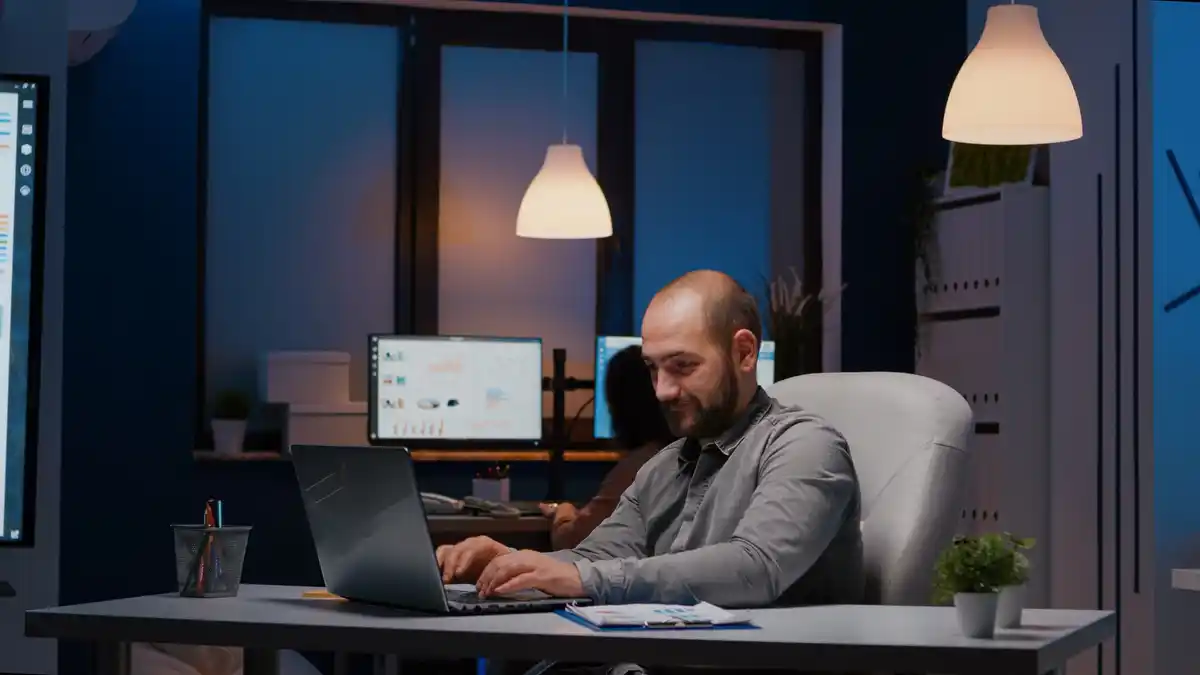 sleeping software engineer with closed laptop in office at night