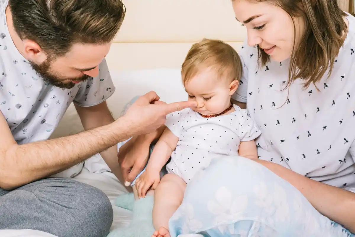 parents comforting crying baby at home