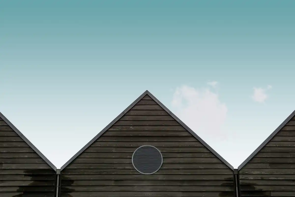 Dutch house roof with old solar panels under cloudy sky