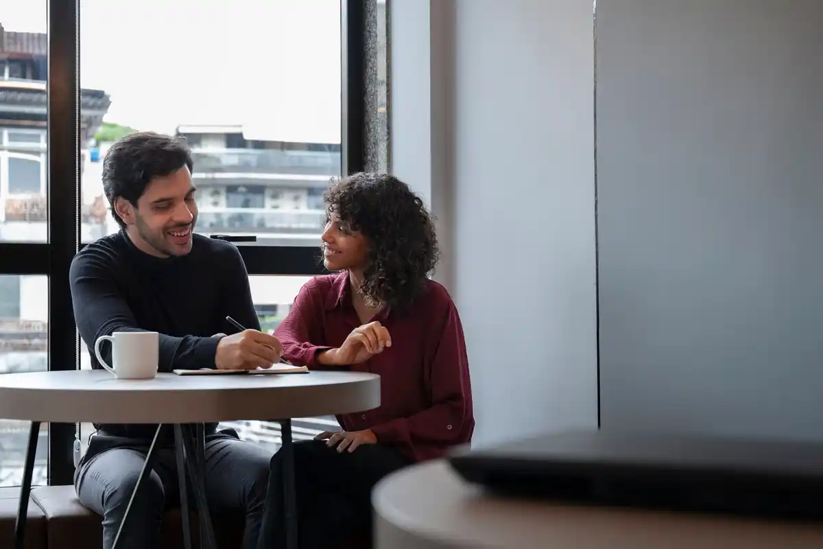 Dutch and Indian colleagues in a meeting room, discussing with smiles, showing cultural greetings